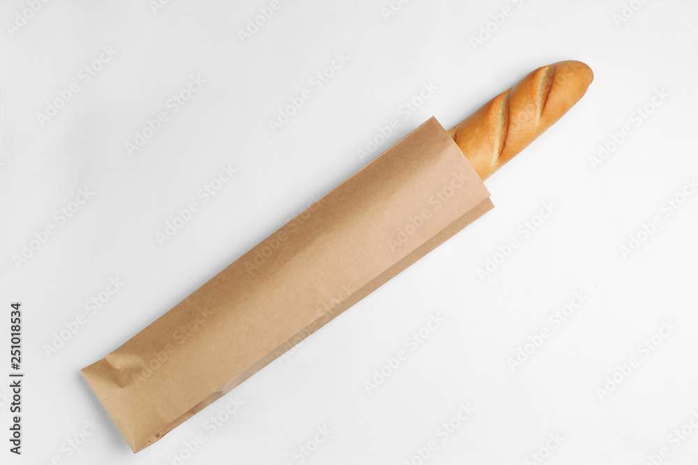 Paper bag with baguette on white background, top view. Space for design Paper bag with baguette on white background, top view. Space for design