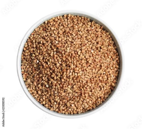 Bowl with uncooked buckwheat on white background, top view