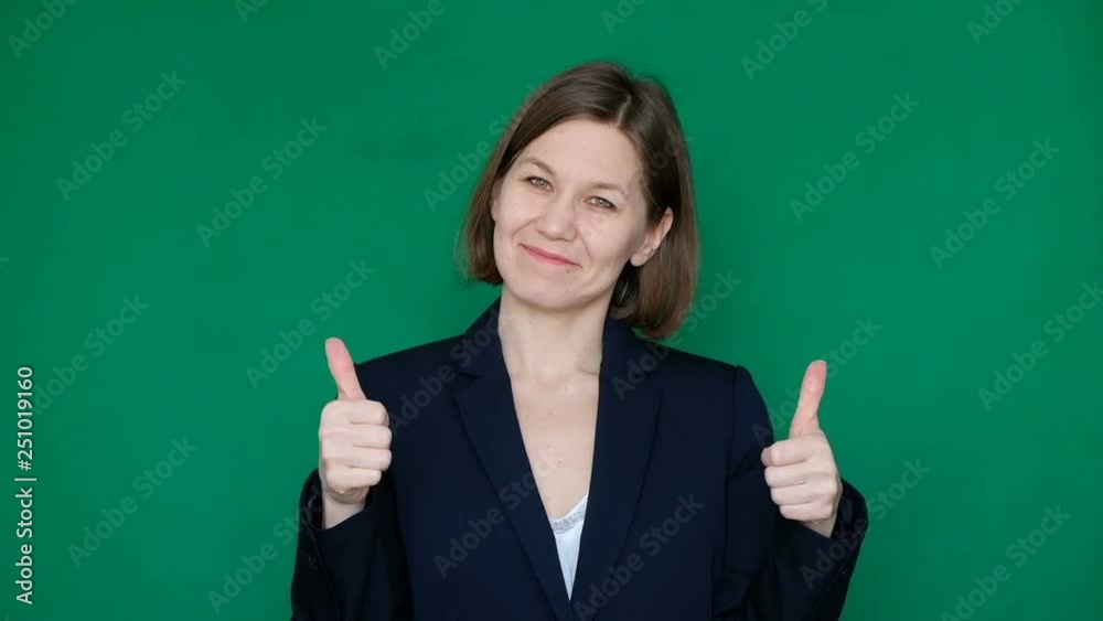 Confident business woman showinf thumb up, looking at camera and smiling on green background. Chroma key. Close up Confident business woman showinf thumb up, looking at camera and smiling on green background. Chroma key. Close up