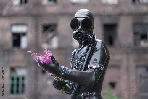 Adult kinky man dressed in fetish latex rubber costume with black mask