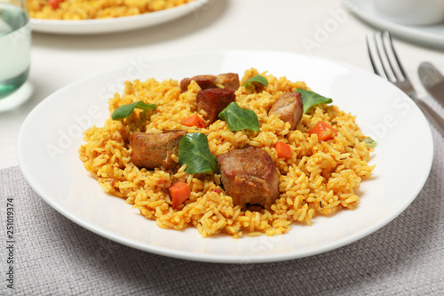 Plate of delicious rice pilaf with meat on table