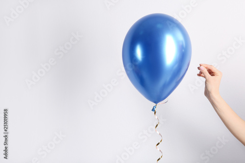 Woman piercing balloon with needle on white background, closeup