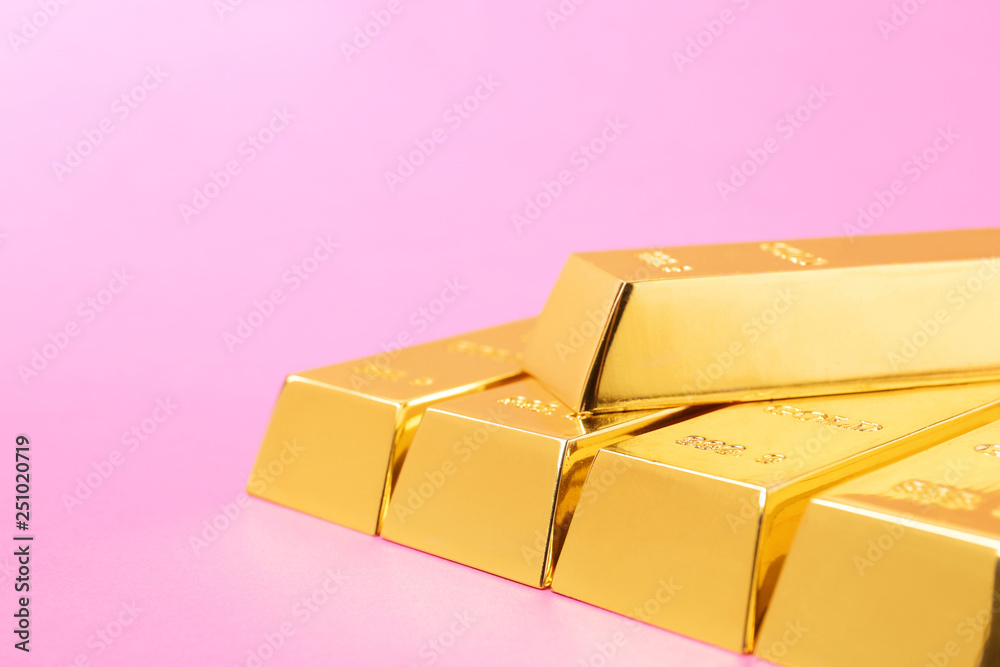 Precious shiny gold bars on color background. Space for text Precious shiny gold bars on color background. Space for text