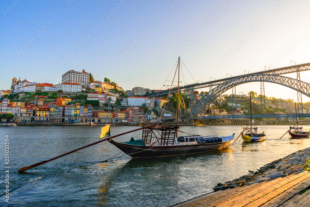 Porto, Portugal old town cityscape on the Douro River with traditional Rabelo boats with wine barrels and bridge