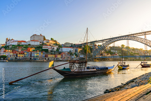 Porto, Portugal old town cityscape on the Douro River with traditional Rabelo boats with wine barrels and bridge photo
