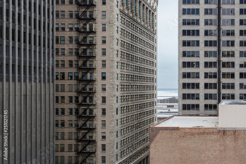 Tightly packed vintage skyscraper buildings with old fashioned steel fire escapes