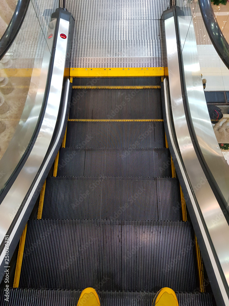 Fototapeta premium escalator with yellow sneakers