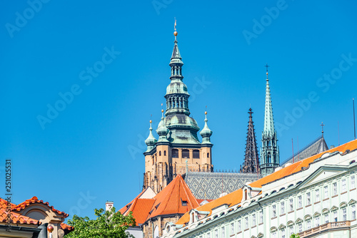 View of Saint Thomas Church main bell tower at blue sky background, Prague, Czech Republic, summer