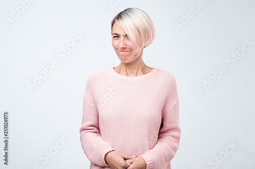 Doubtful indecisive beautiful woman biting lips looking at camera expressing her uncertainty.