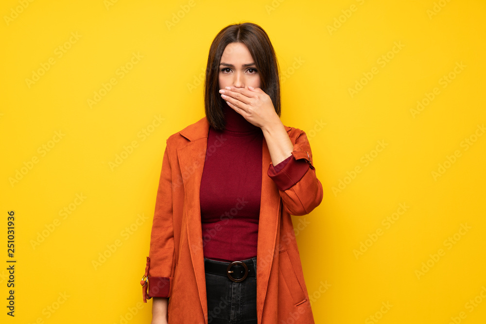 Young woman with coat covering mouth with hands for saying something inappropriate Young woman with coat covering mouth with hands for saying something inappropriate