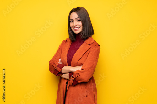 Young woman with coat with arms crossed and looking forward © luismolinero