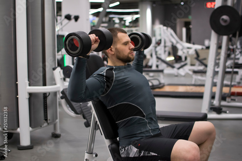 Man in the gym with kettlebells and weights.