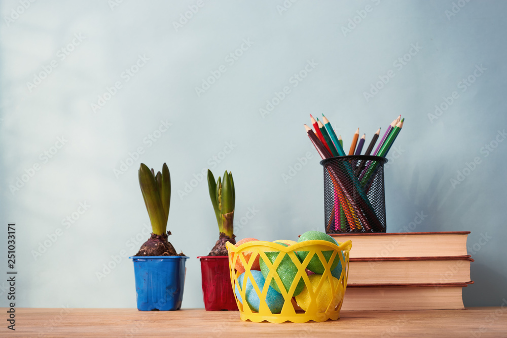 School supplies, Easter eggs and flowers on wooden table