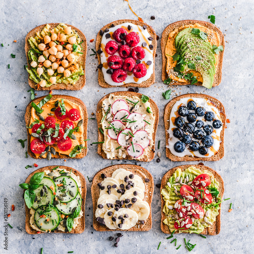 Variety of toasts with fruit and vegetables on table photo