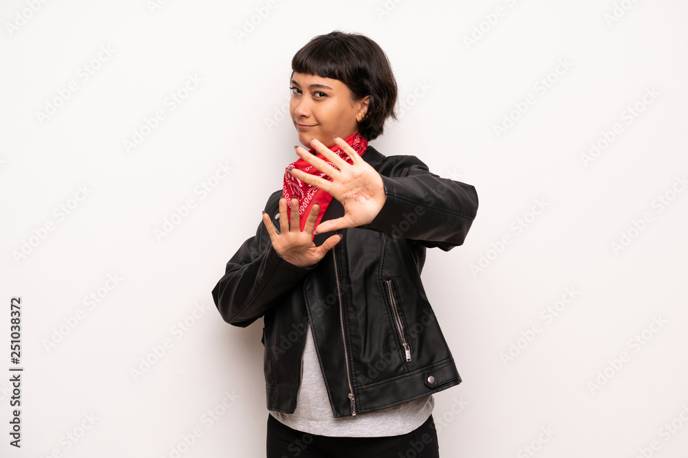 Woman with leather jacket and handkerchief is a little bit nervous and scared stretching hands to the front Woman with leather jacket and handkerchief is a little bit nervous and scared stretching hands to the front