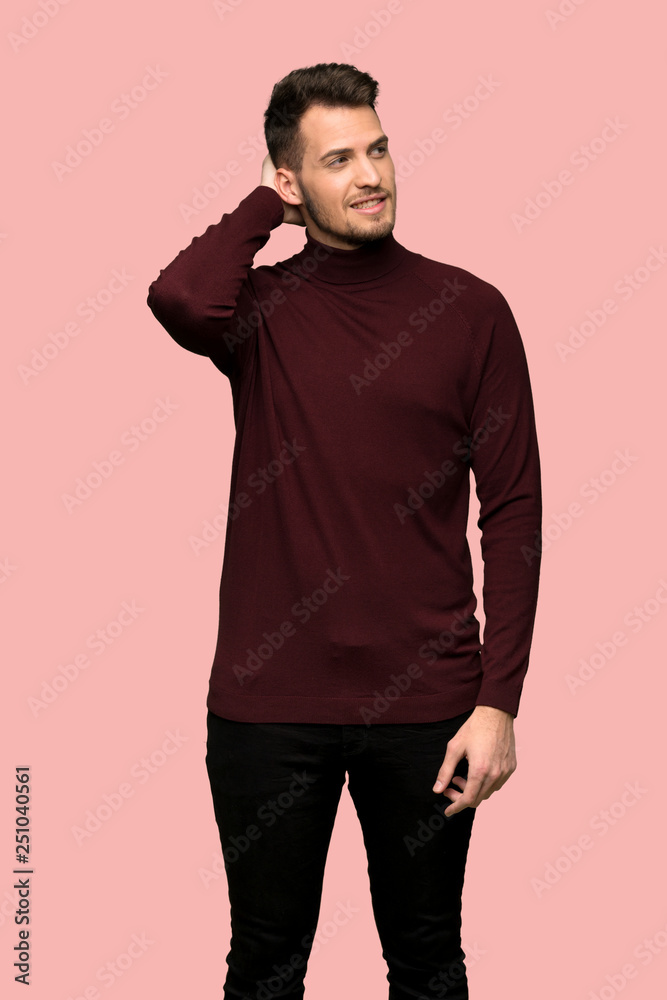Man with turtleneck sweater thinking an idea while scratching head over pink background Man with turtleneck sweater thinking an idea while scratching head over pink background
