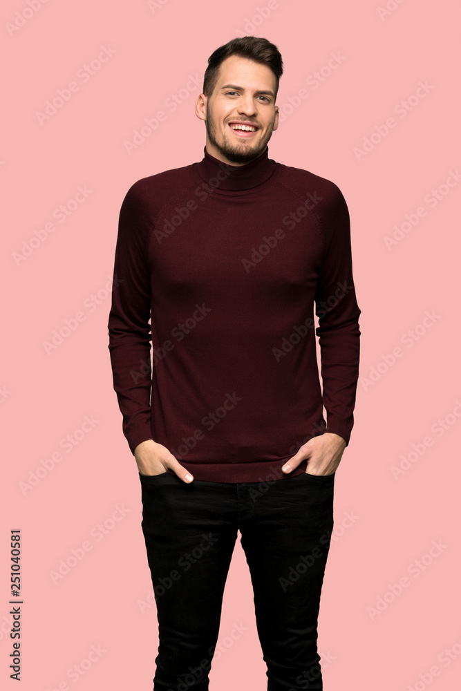 Man with turtleneck sweater smiling a lot over pink background Man with turtleneck sweater smiling a lot over pink background