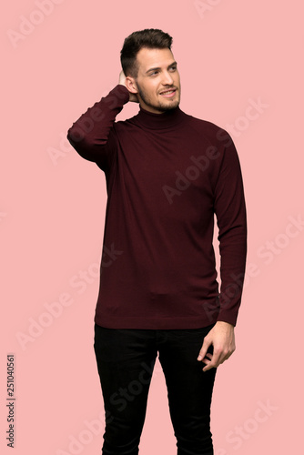 Man with turtleneck sweater thinking an idea while scratching head over pink background