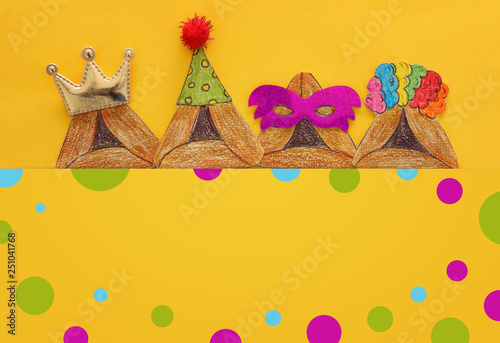 Purim celebration concept (jewish carnival holiday). Traditional hamantash cookies cutted from paper and painted