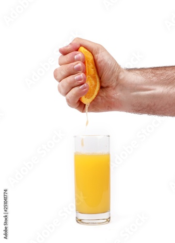 fresh squeezed orange juice with hand squeezing orange - glass with fresh squeezed orange juice and oranges isolated on white