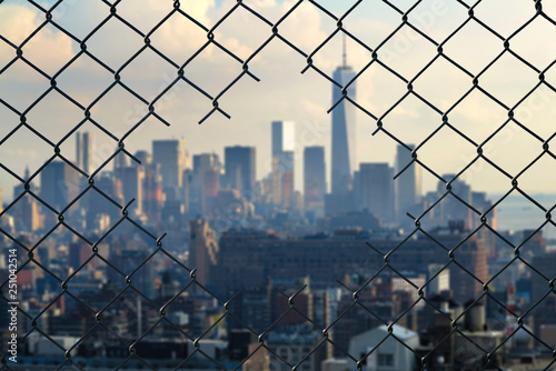 View on the New York city through the hole of steel mesh wire fence. Concept