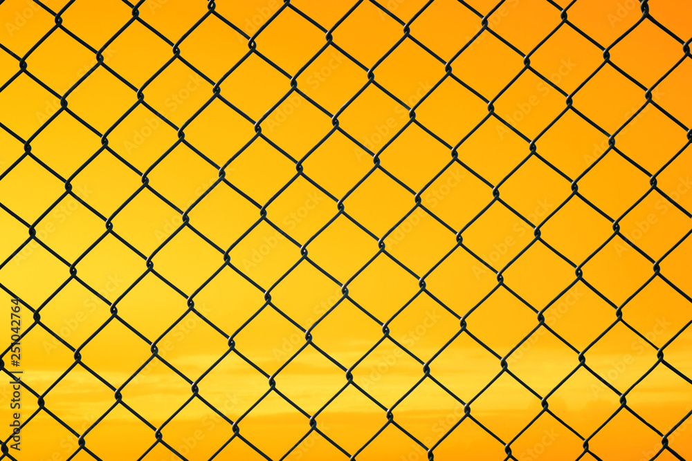 Conceptual image of twilight sky with effect of light yellow tone and steel mesh wire fence. Concept of hope and freedom Conceptual image of twilight sky with effect of light yellow tone and steel mesh wire fence. Concept of hope and freedom
