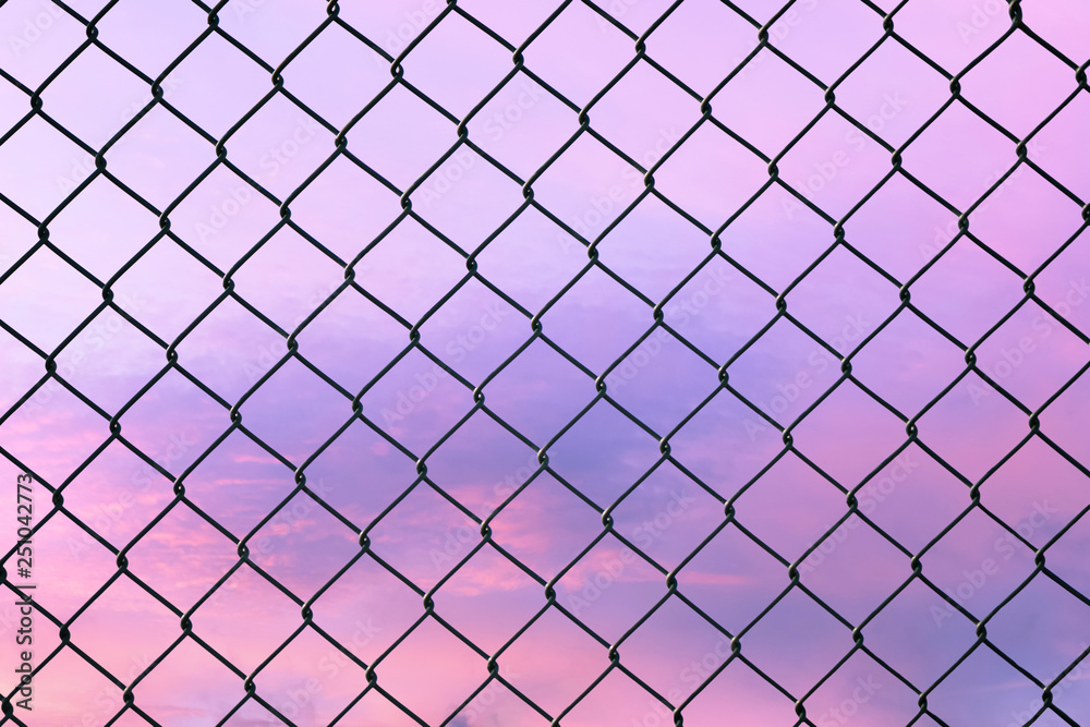 Conceptual image of twilight sky with effect of light pastel tone and steel mesh wire fence. Concept of hope and freedom Conceptual image of twilight sky with effect of light pastel tone and steel mesh wire fence. Concept of hope and freedom