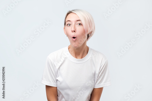 Funny european woman opening mouth widely and popping eyes out in surprise photo