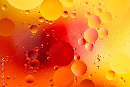 colorful oily drops  in water with colorful background, close-up 