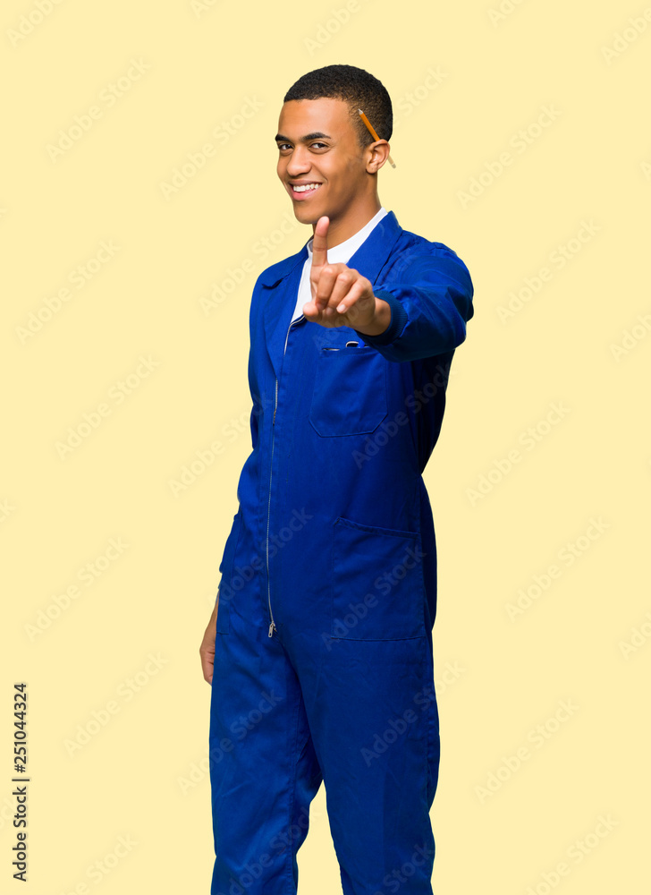 Young afro american worker man showing and lifting a finger on isolated background Young afro american worker man showing and lifting a finger on isolated background