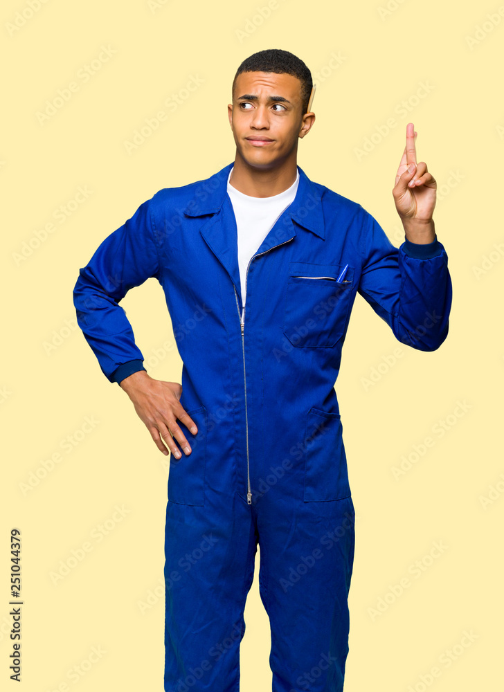 Young afro american worker man with fingers crossing and wishing the best on isolated background Young afro american worker man with fingers crossing and wishing the best on isolated background