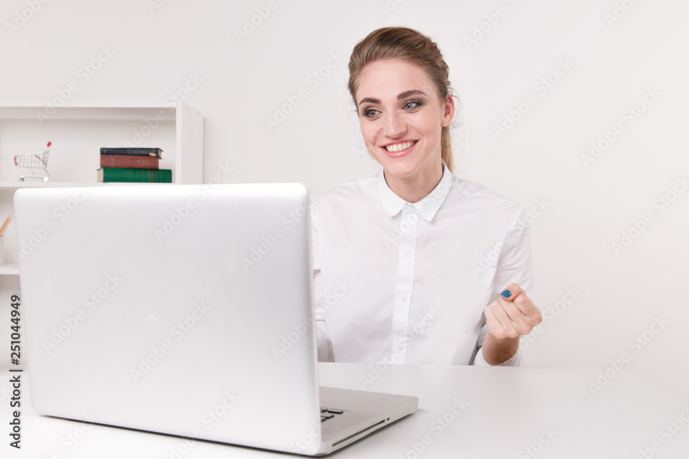 Young businesswoman in a white blouse sitting in an office. Office worker sitting infront of new white computer.