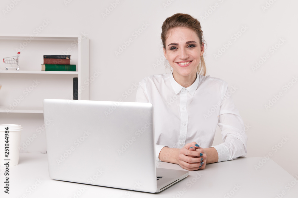 Pretty smiling office woman sitting infront of her computer at work day Pretty smiling office woman sitting infront of her computer at work day