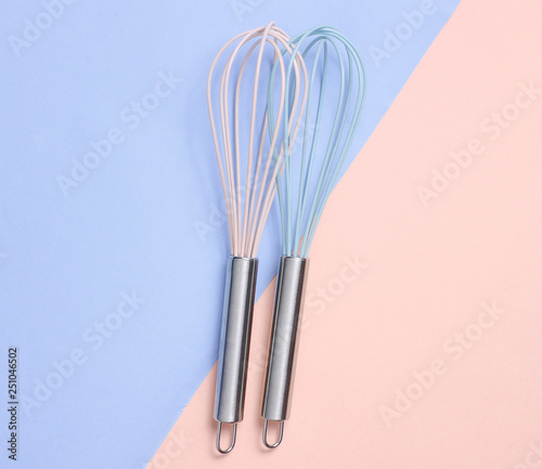 Two whisk on blue pink pastel background. Top view  minimalism.