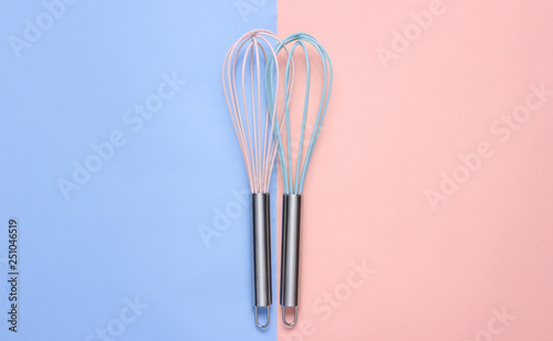 Two whisk on blue pink pastel background. Top view  minimalism.