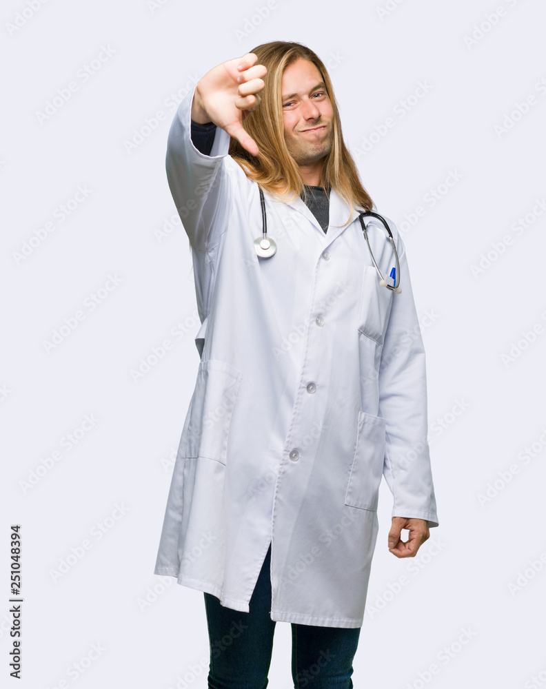 Doctor man showing thumb down sign with negative expression on isolated background Doctor man showing thumb down sign with negative expression on isolated background