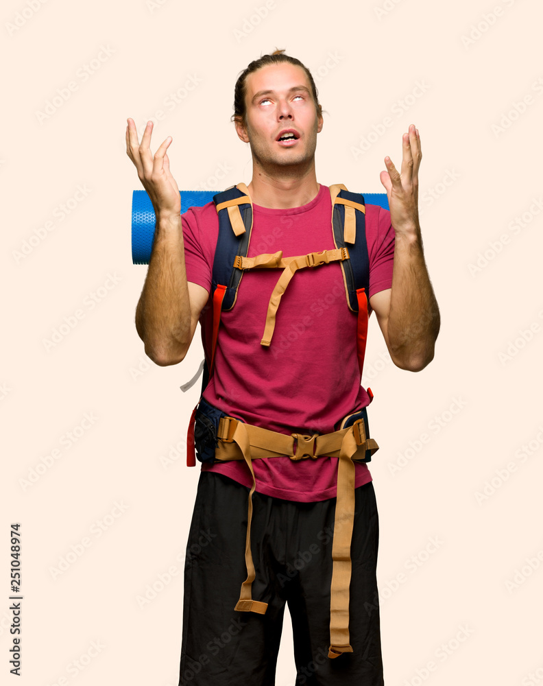 Hiker man with mountain backpacker frustrated by a bad situation on isolated background Hiker man with mountain backpacker frustrated by a bad situation on isolated background