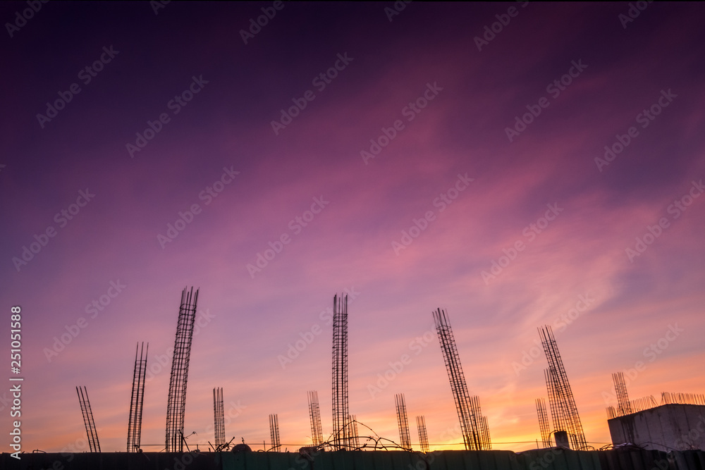 silhouettes of building structures against the sunset sky