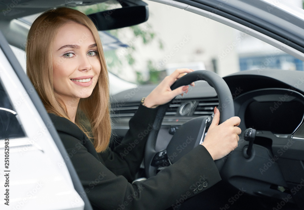 Naklejka premium Blonde sitting in new automobile, buyer of car.