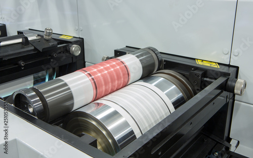 Flexography printing process on in-line press machine. Photopolymer plate stuck on printing cylinder, substrate is sandwiched between the plate and the impression cylinder to transfer the ink. photo