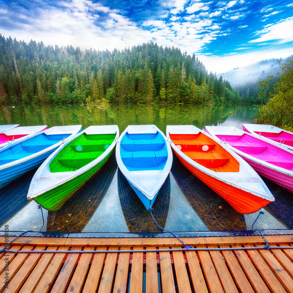 Boats on majestic mountain lake Lacul Rosu or Red Lake or Killer Lake