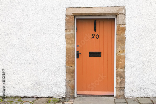 Orange old wooden door rustic ancient house entrance in Culross