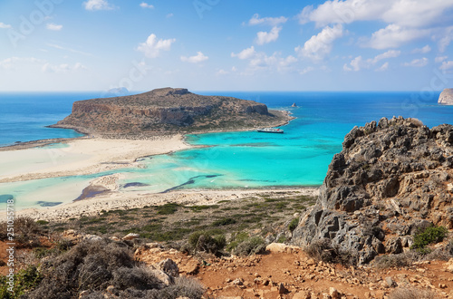 Marvelous landscape of a rocky hill, Balos beach with fantastic white sand and three seas: Ionian, Aegean and Libyan. Great summer day. Popular touristic resort, coast of island Crete, Greece.