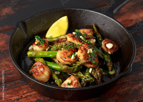 Konstfotografi Scallops seared in garlic and parsley butter served in cast iron skillet