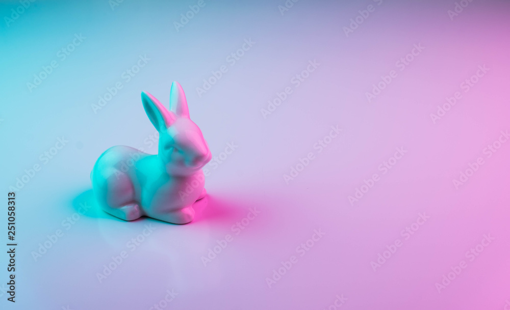 White Easter bunny with colorful ultraviolet holographic neon lights. Creative concept. - obrazy, fototapety, plakaty 