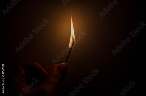 burning match in female hand in the dark photo