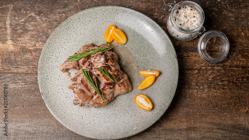 Food banner. Roasted turkey meat with citrus and rosemary on a large gray plate. Top view
