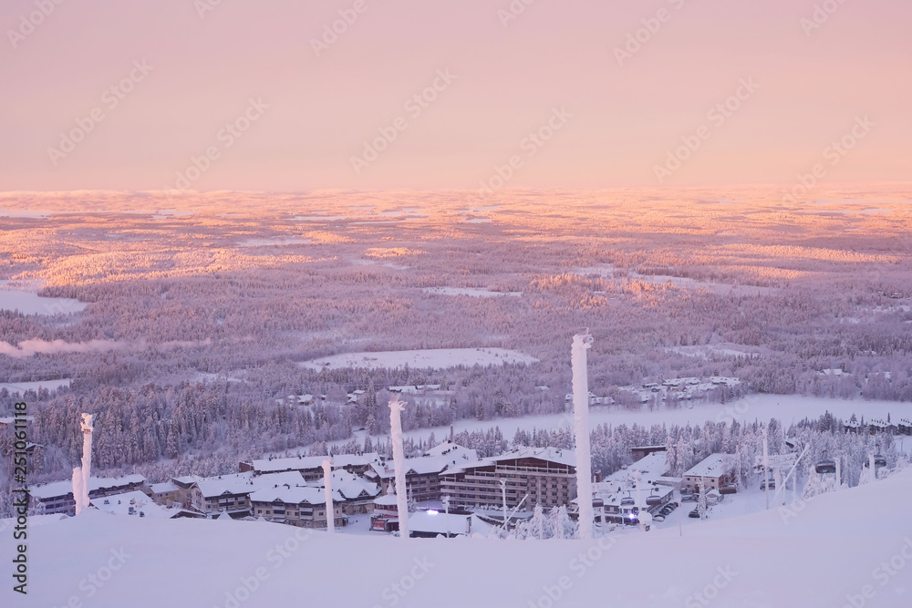 Sunrise over the forests of Lapland. View from Ruka mountain in winter.