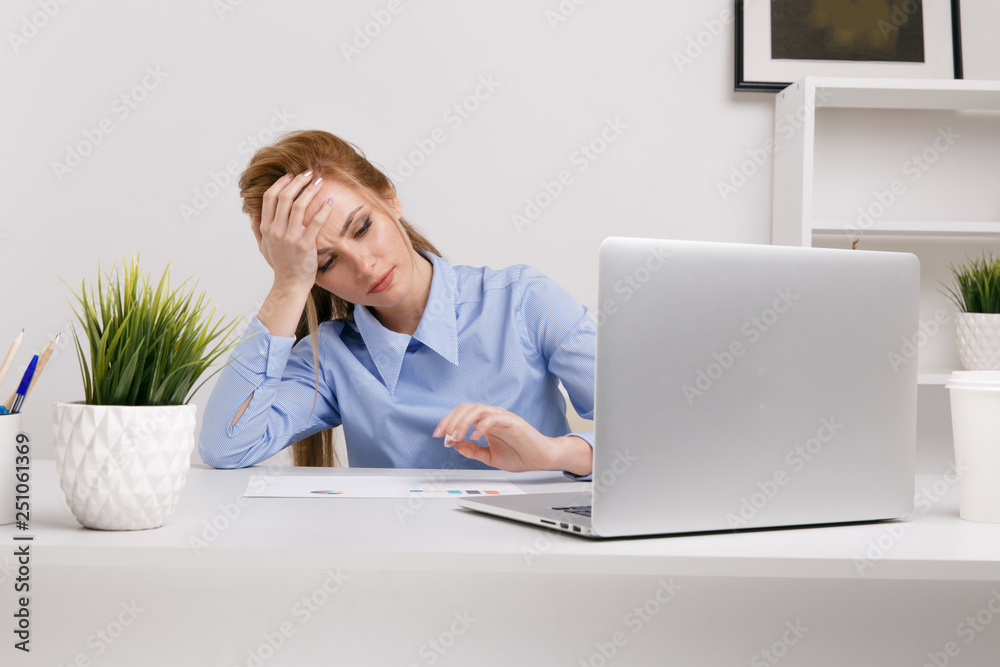Young office girl sitting at her workplace feeling bad. Woman has a headache Young office girl sitting at her workplace feeling bad. Woman has a headache