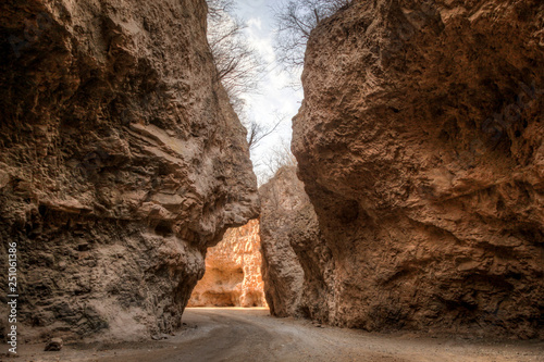 Rough canyon walls almost touch over a small dirt road in rural China photo